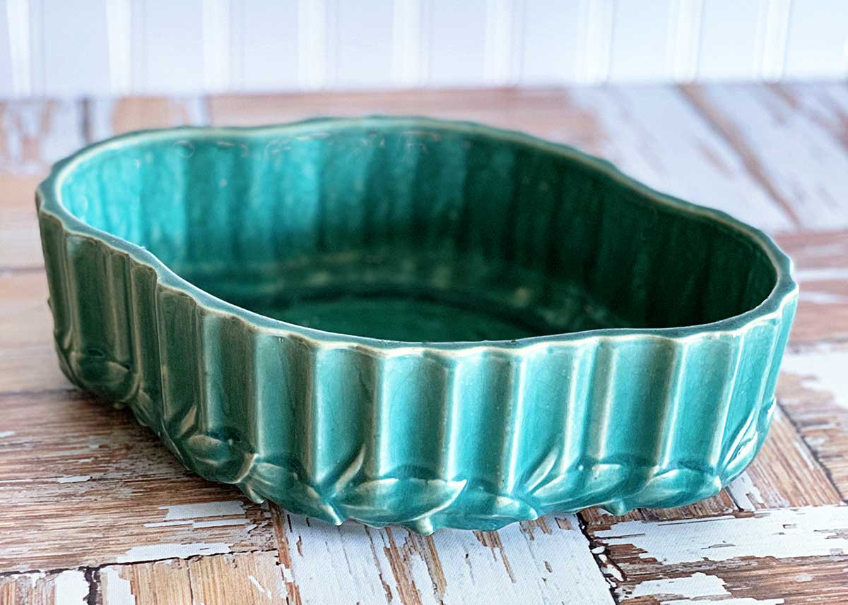 Turquoise colored McCoy pottery bulb bowl - shallow in design with ribs and leaves on the sides. 