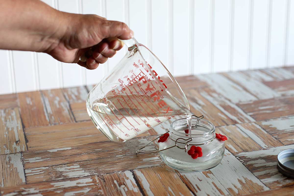 Pouring sugar water into a hummingbird feeder.