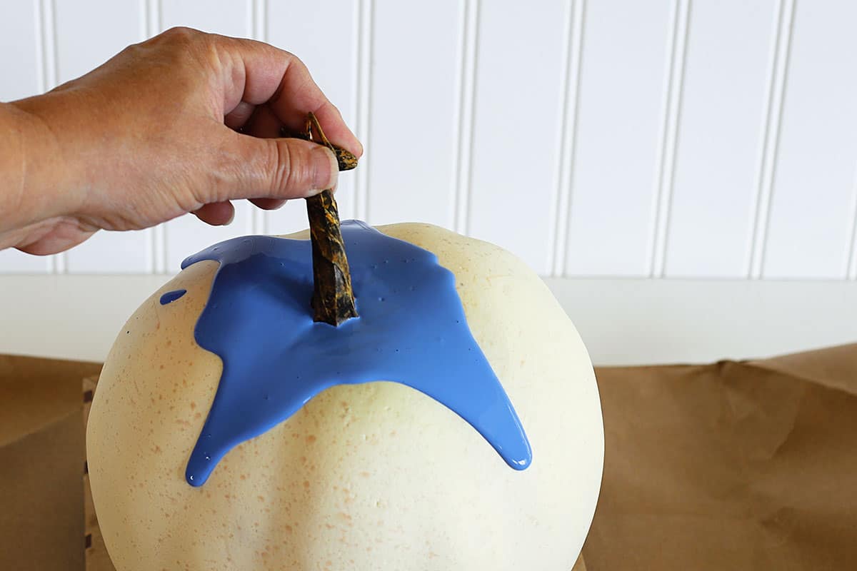 Tilting the pumpkin to drip the paint down the sides.
