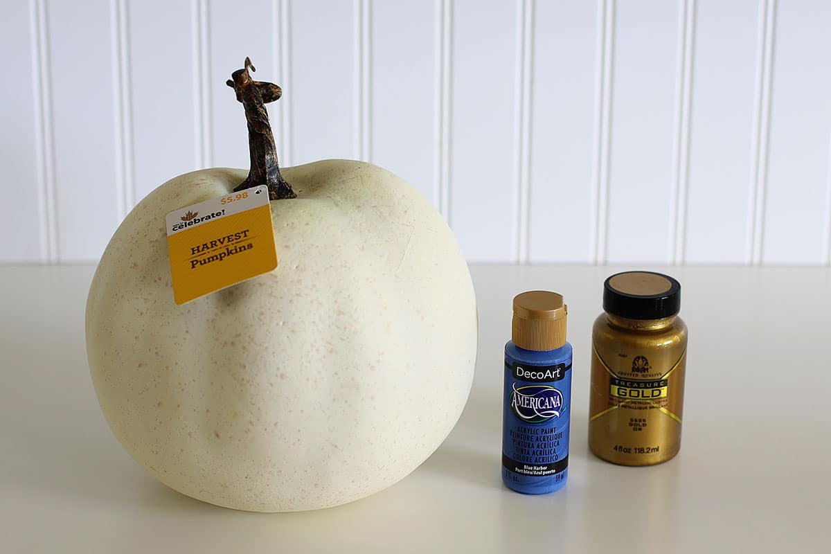 White faux pumpkin, blue craft paint and metallic gold craft paint which will be used to make a drip paint pumpkin.