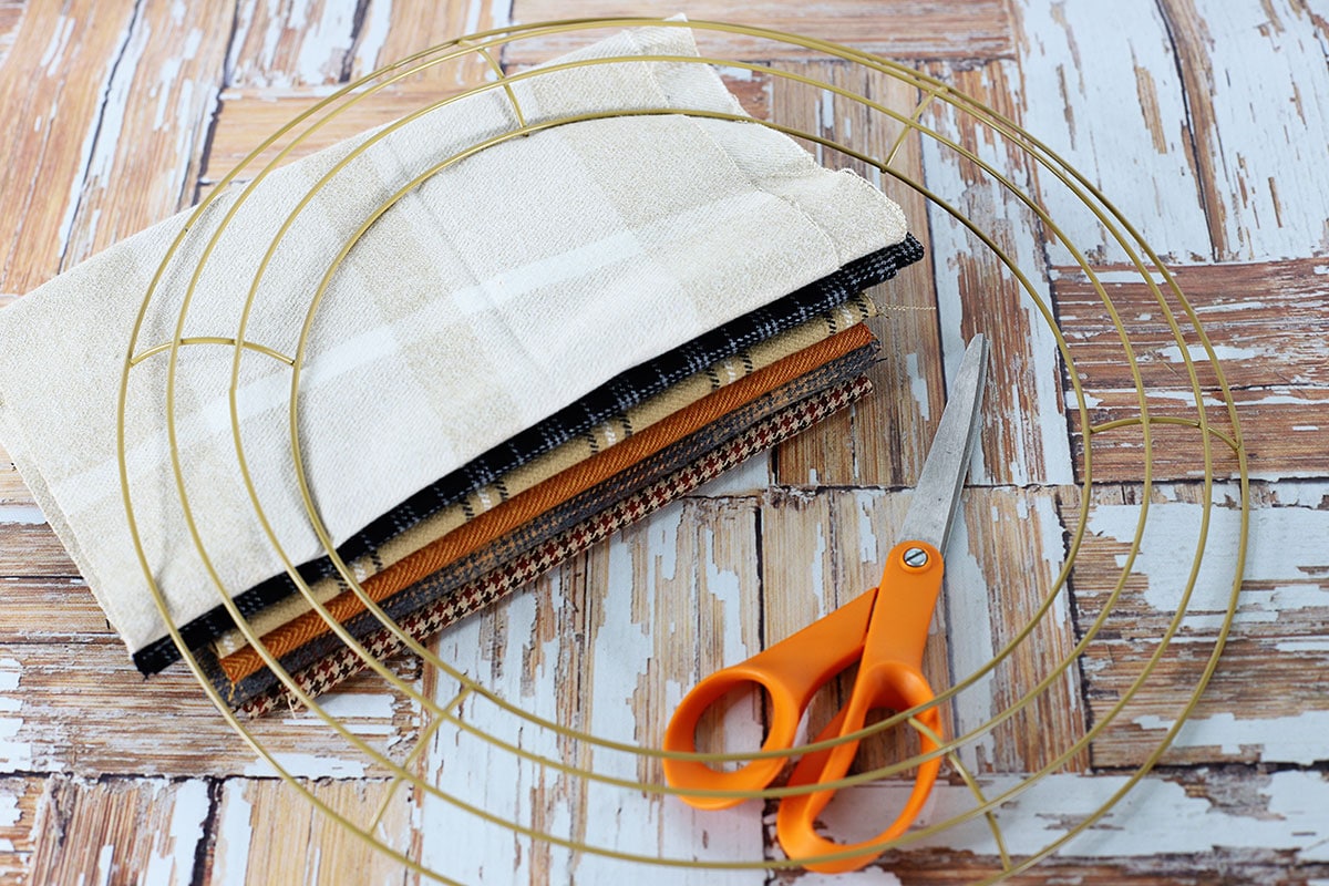 Supplies for making a rag wreath including 6 patterns of flannel fabric, wreath form and scissors.