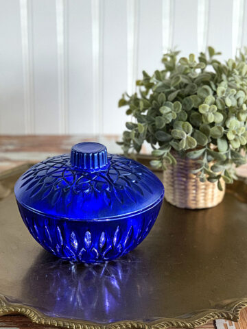 How to upcycle thrift store glass to make unique and stylish home decor - a blue glass candy dish setting on a bronze serving tray.