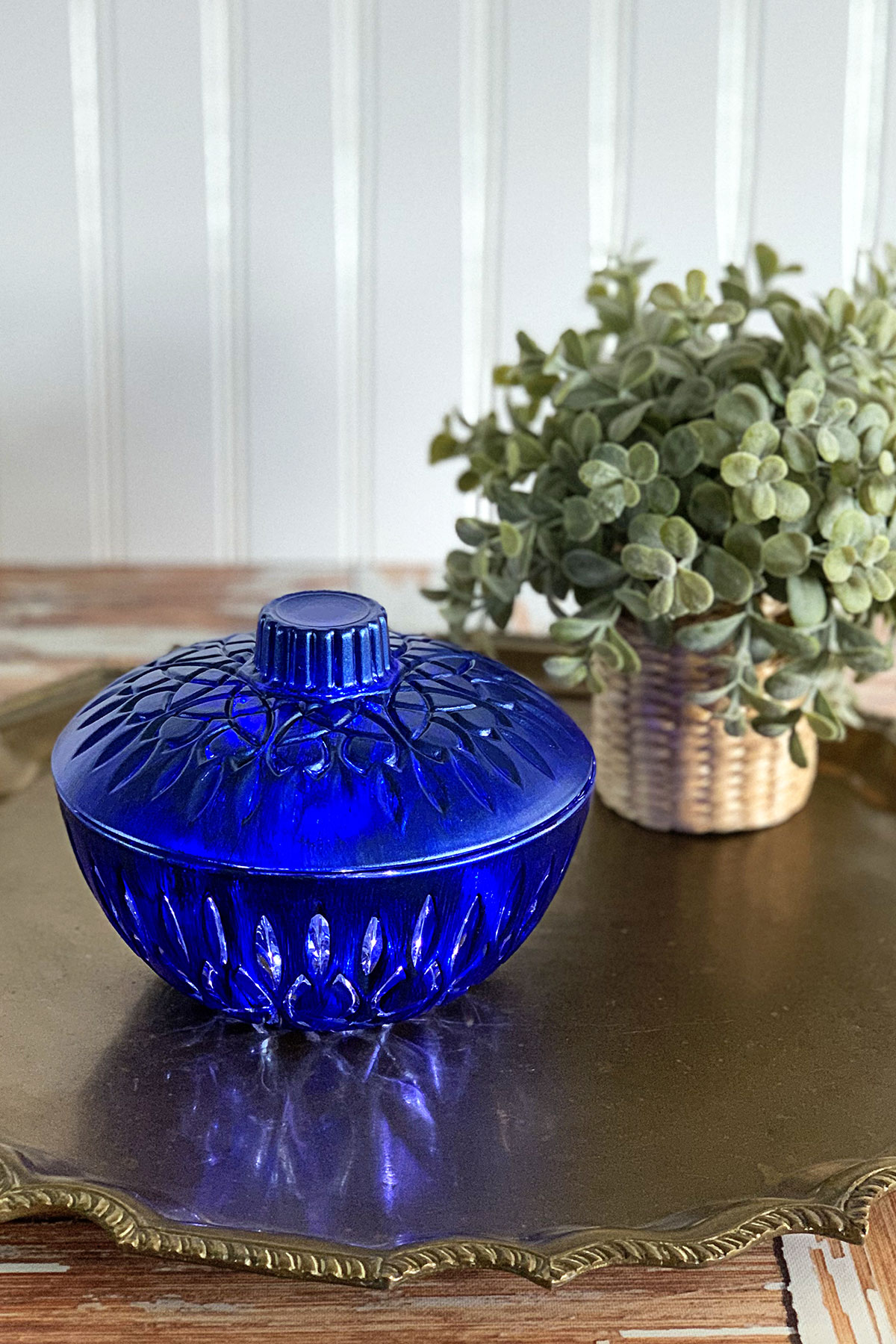 How to upcycle thrift store glass to make unique and stylish home decor - a blue glass candy dish setting on a bronze serving tray.