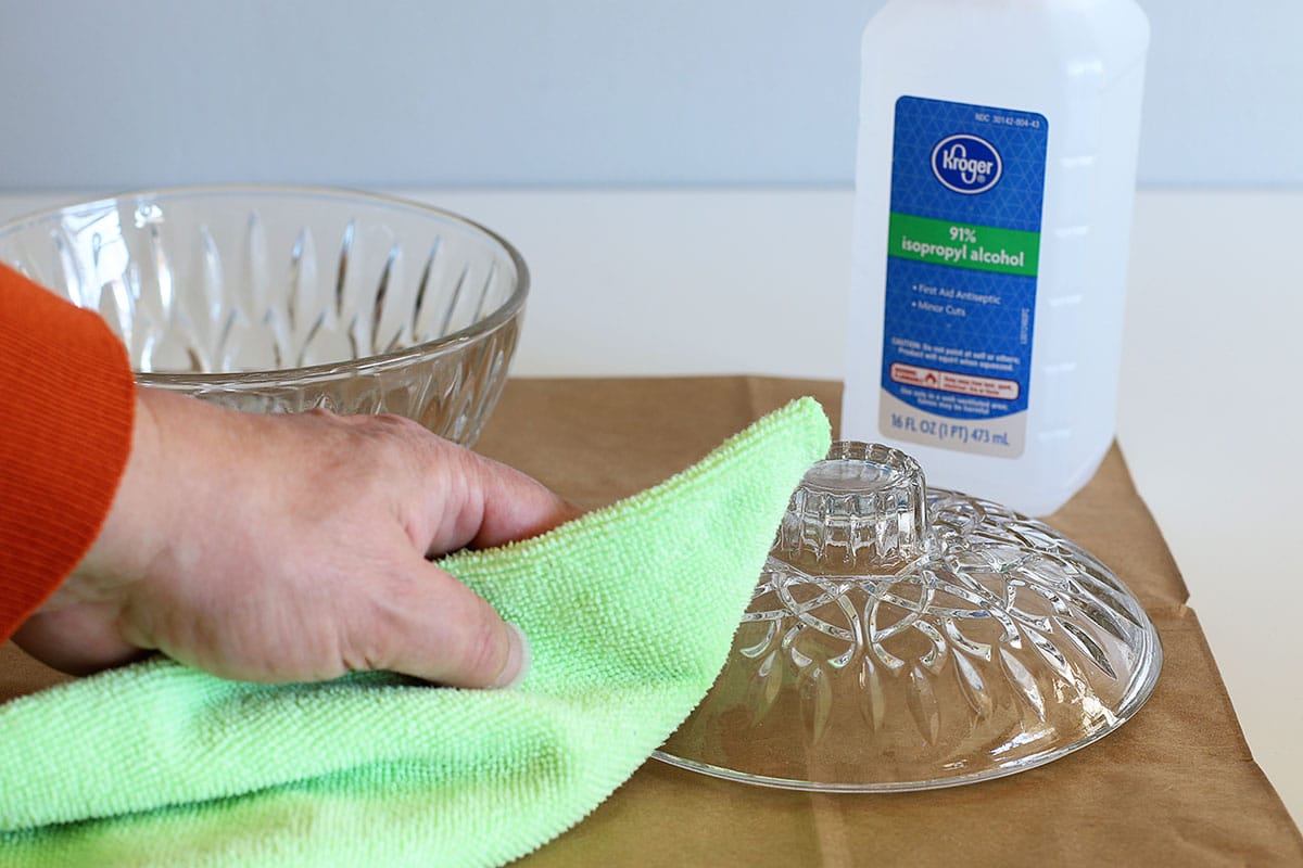 Cleaning glass with rubbing alcohol and a rag to remove dirt and grease.