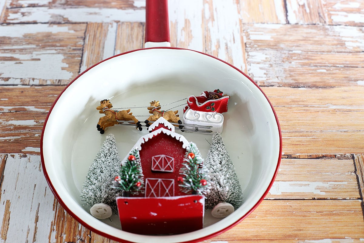 Santa and sleigh flying over a red barn.