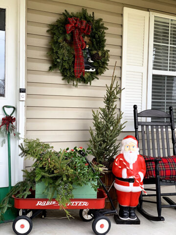 A little red wagon, vintage blow mold Santa and classic ice skates add a touch of whimsy and nostalgia to your holiday decorating on the front porch.