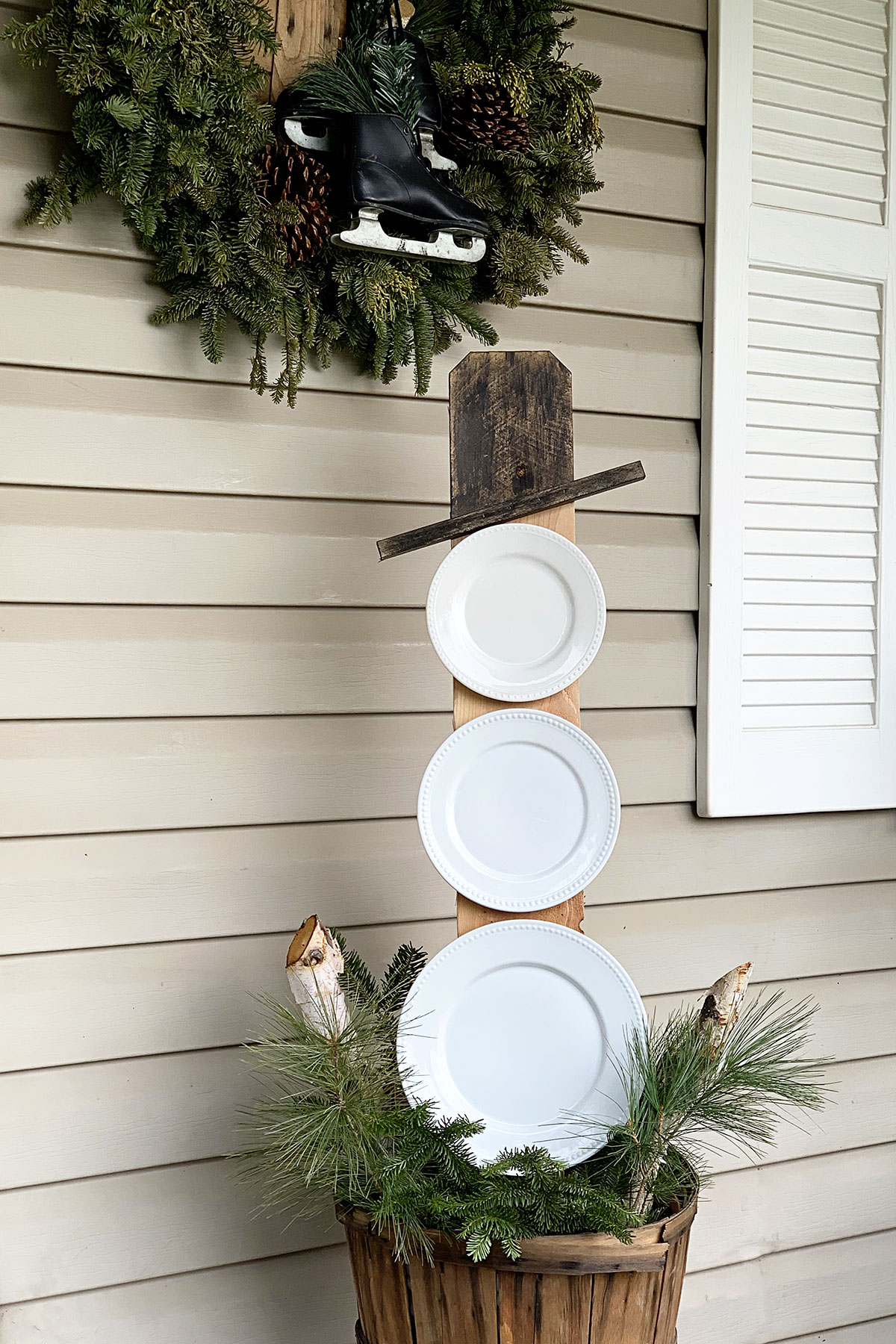 Snowman made from repurposed white plates. Used as porch decor for after Christmas.