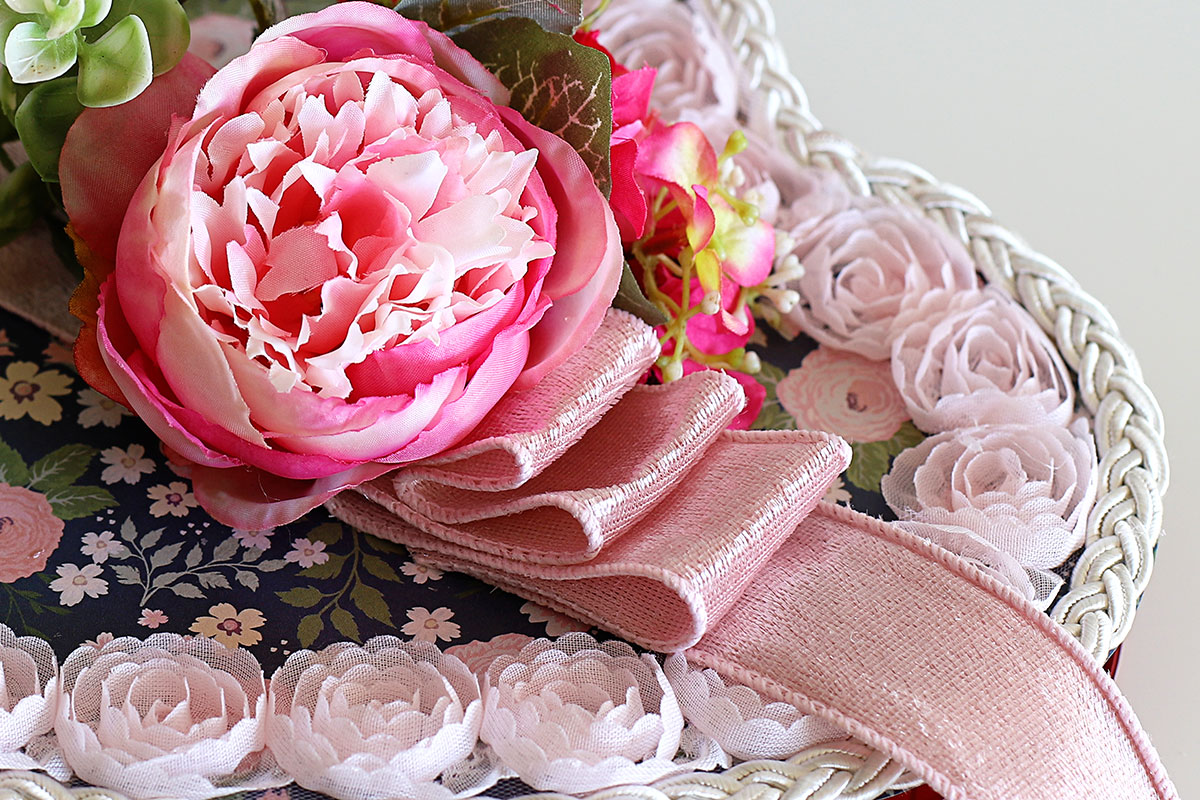 Attaching ribbon to vintage Valentine's Day candy box.