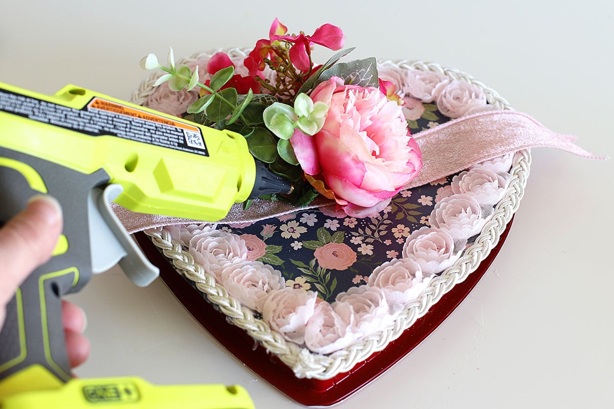 Attaching flowers to the top of a DIY vintage style Valentine's Day candy box.