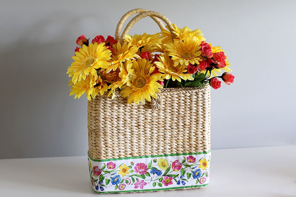 A Claire Murray purse with flowers in it - will be used as a summer door wreath.
