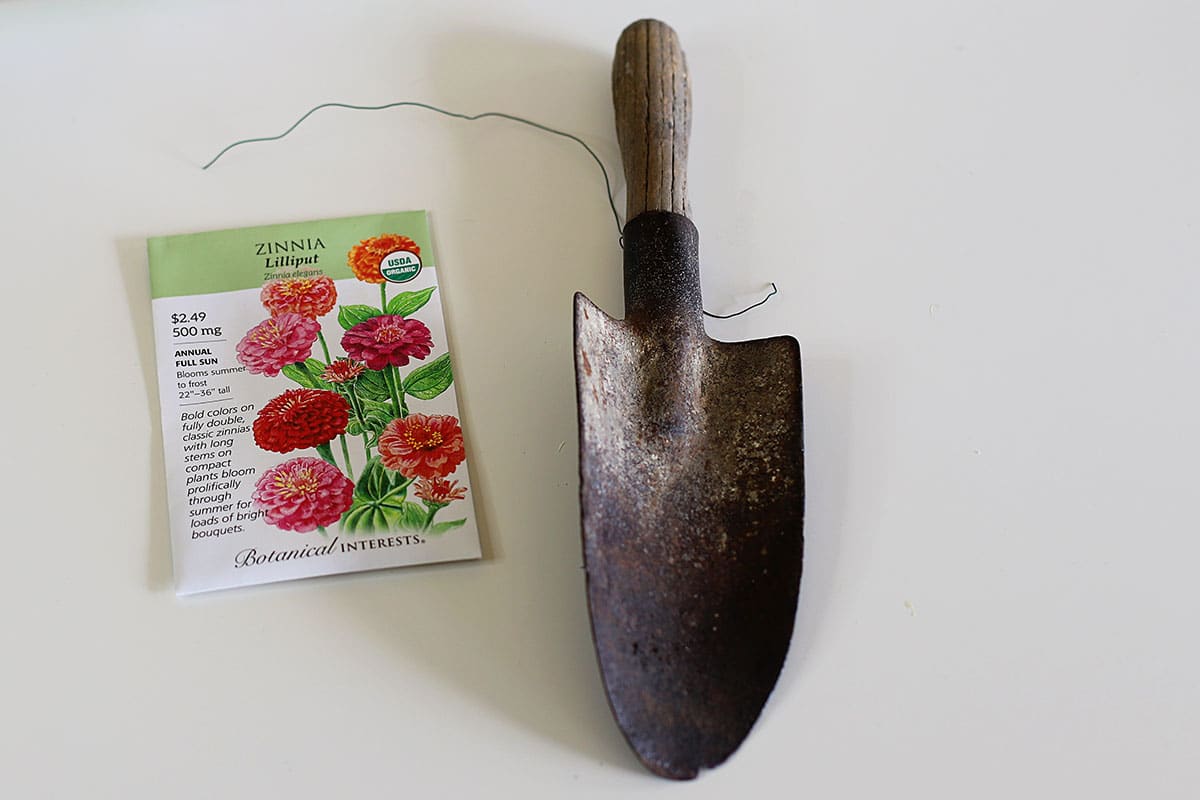 Vintage wooden garden trowel and a packet of zinnia seeds.