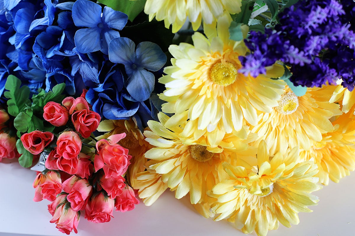Faux flowers in shades of yellow, bright pink and blue.