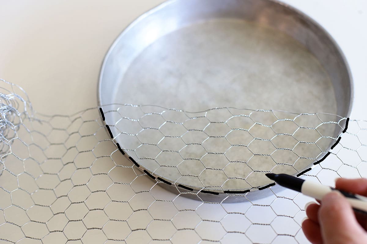 Measuer along the bottom edge of the cake pan so you kow where to cut the chicken wire.