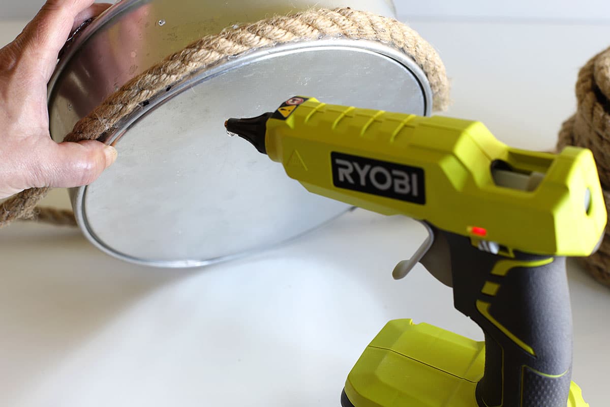 Gluing rope to the bottom of the cake pan for a nautical look.