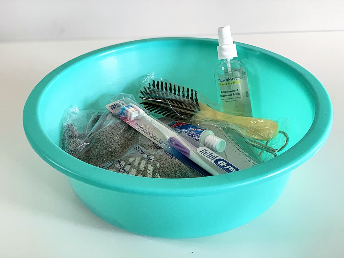 Plastic basin from the hospital filled with various toiletries. 