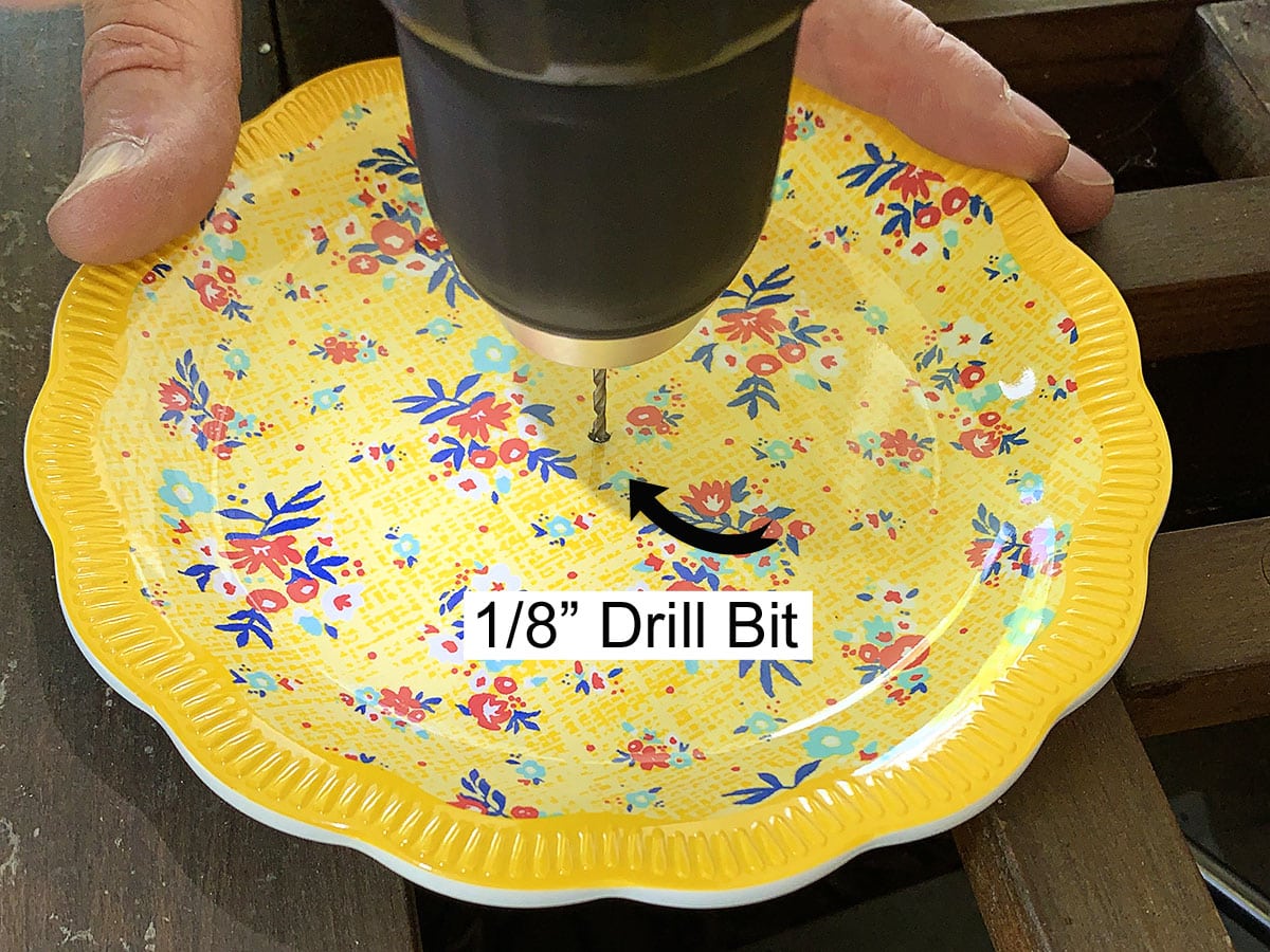 Drilling a pilot hole in a plate with a ⅛" drill bit.