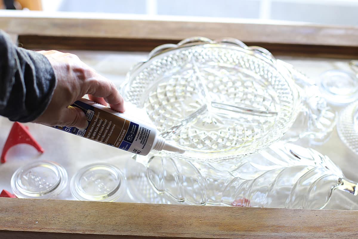 Applying glue to the back of glass plates.