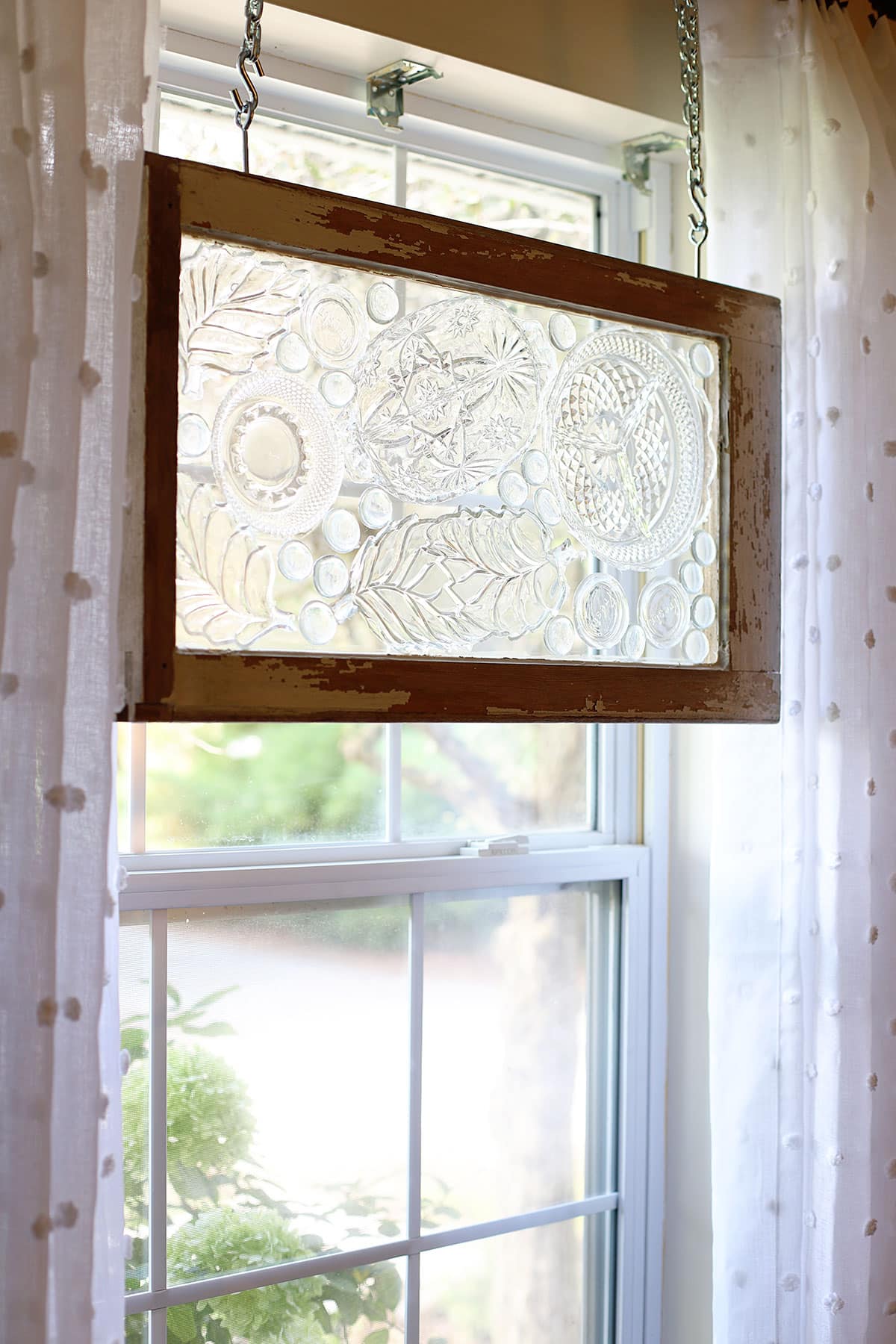 Using thrift store glass plates and an old window to make a stained glass window.