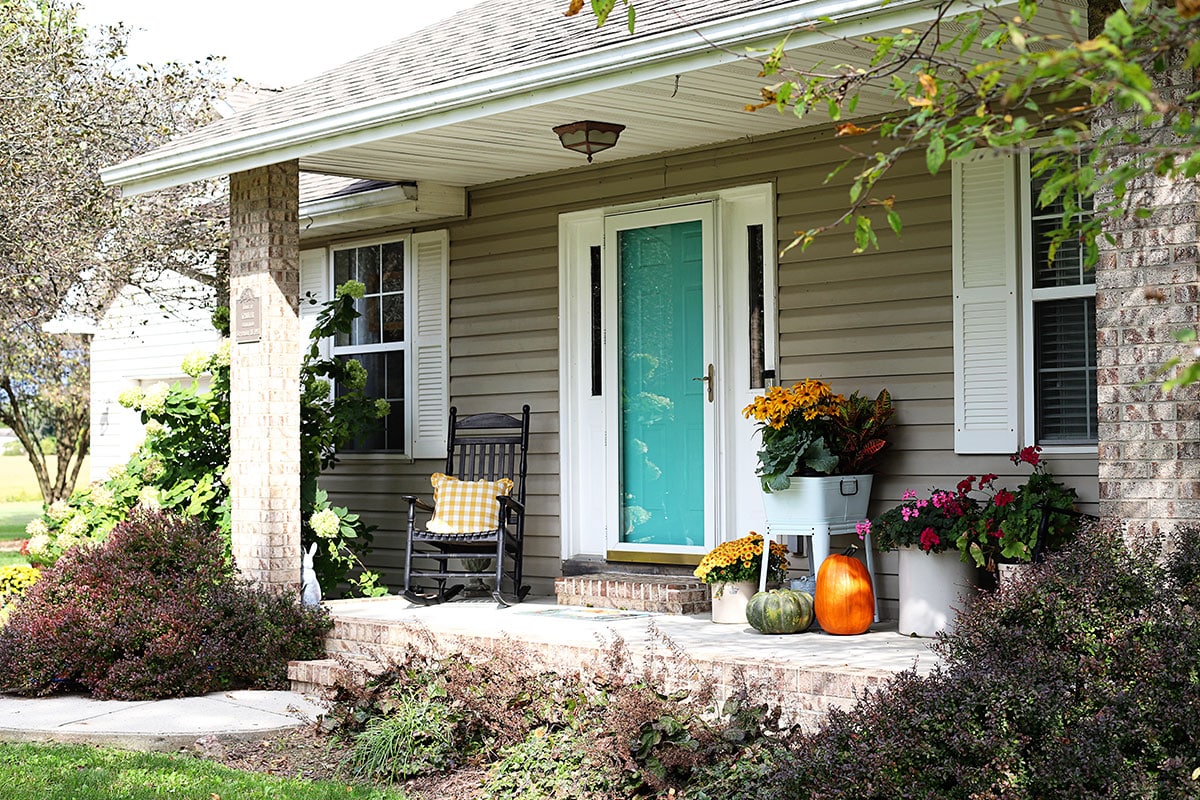 A simple fall porch decorated in yellows and orange.