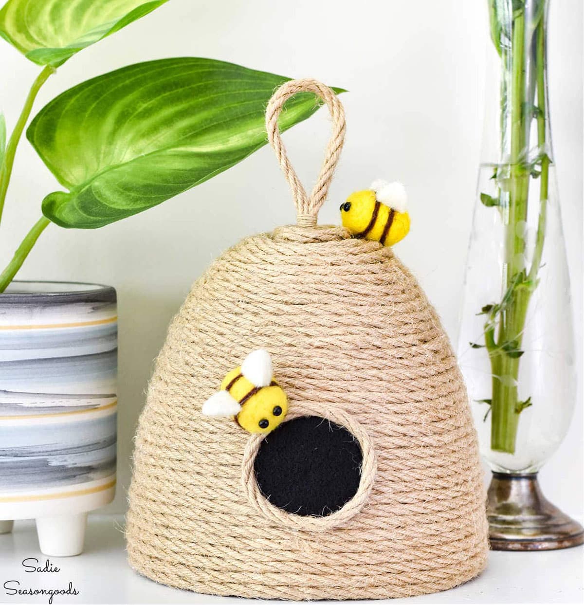 DIY bee hive decor piece made from glass light covering and jute rope.