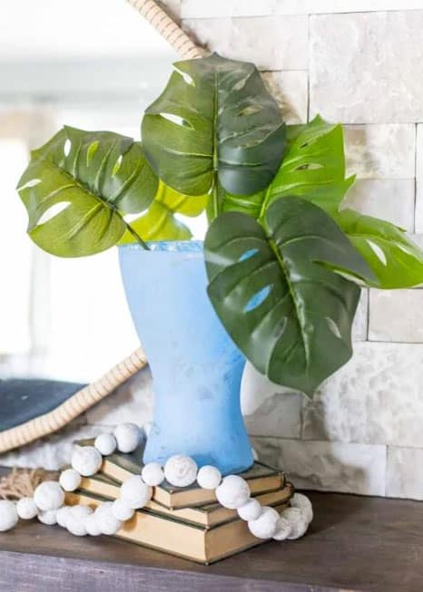 Sea glass colored vase on a mantel.
