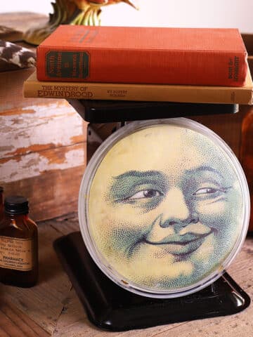 Vintage metal kitchen scale repurposed into fall decor - has a man in the moon face on the dial.