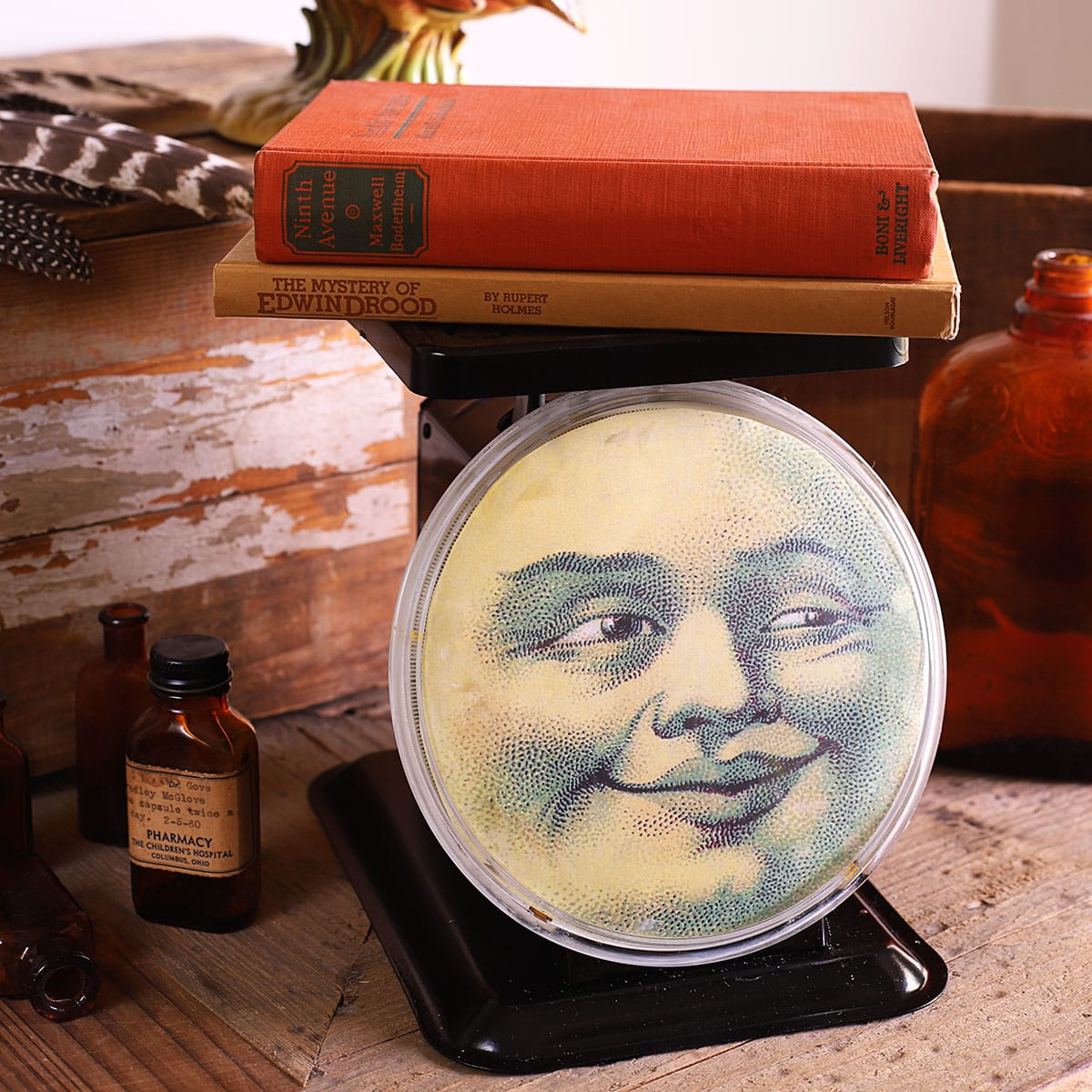 Vintage metal kitchen sdcale repurposed with a man in the moon face on the scale plate. 