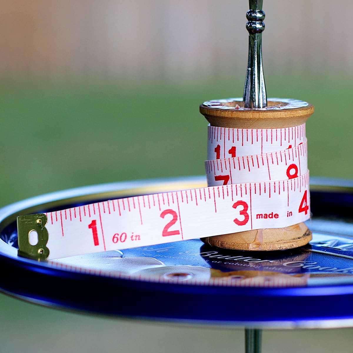 a sewing themed bird feeder made from a Danish butter cookies tin.