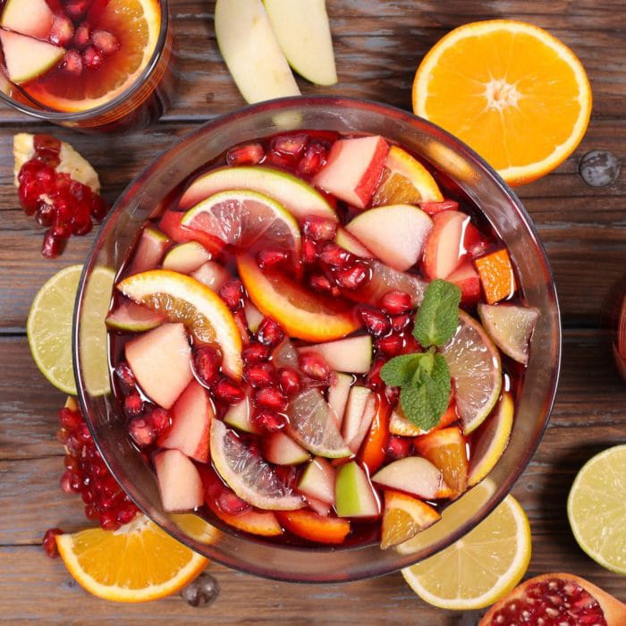A traditional sangria recipe for Christmas using oranges, apples. pomegranate and cranberries.