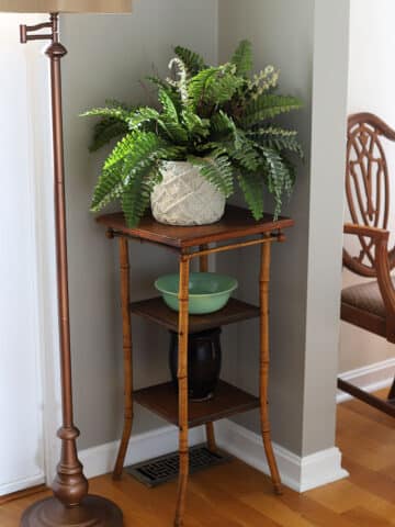 3-tiered bamboo side table used as a plant stand.