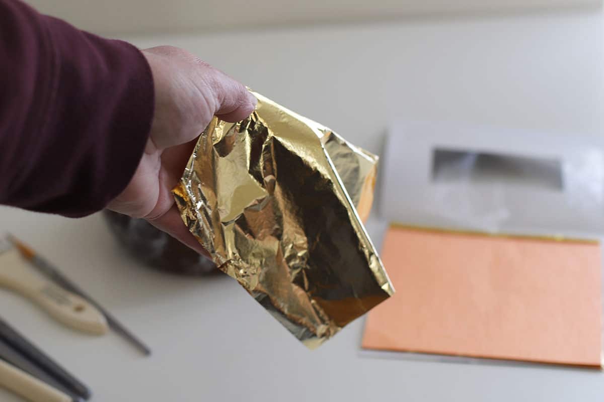 A sheet of gold leaf which will be applied to the wooden bowl.