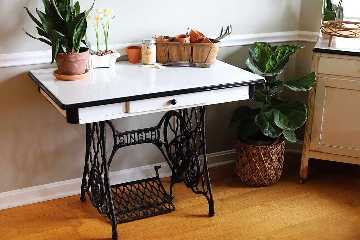 Vintage porcelain enamel kitchen table combined with vintage cast iron Singer sewing machine base.