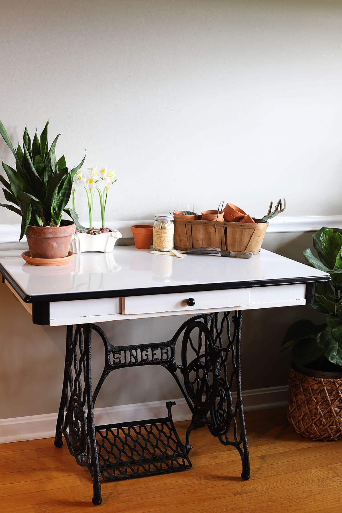 Vintage porcelain enamel kitchen table combined with vintage cast iron Singer sewing machine base.