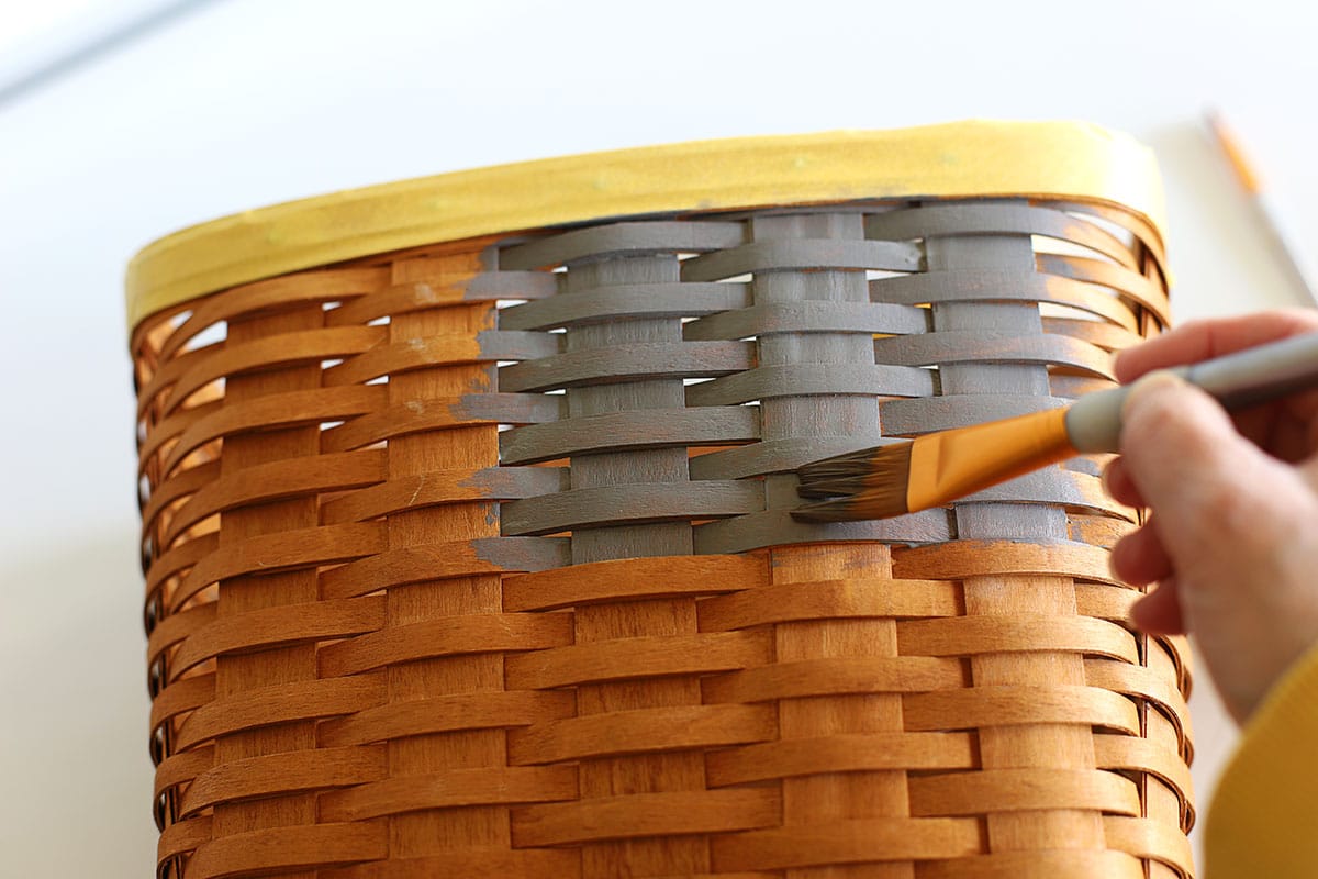 Using gray paint and a flat paintbrush to paint the Longaberger basket.