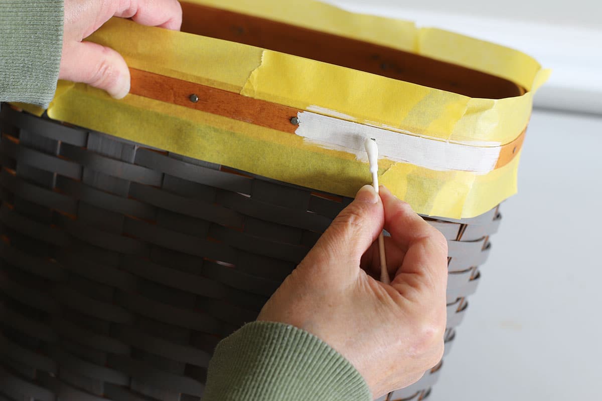 Using a q-tip to remove paint from the nails on the Longaberger basket we painted.