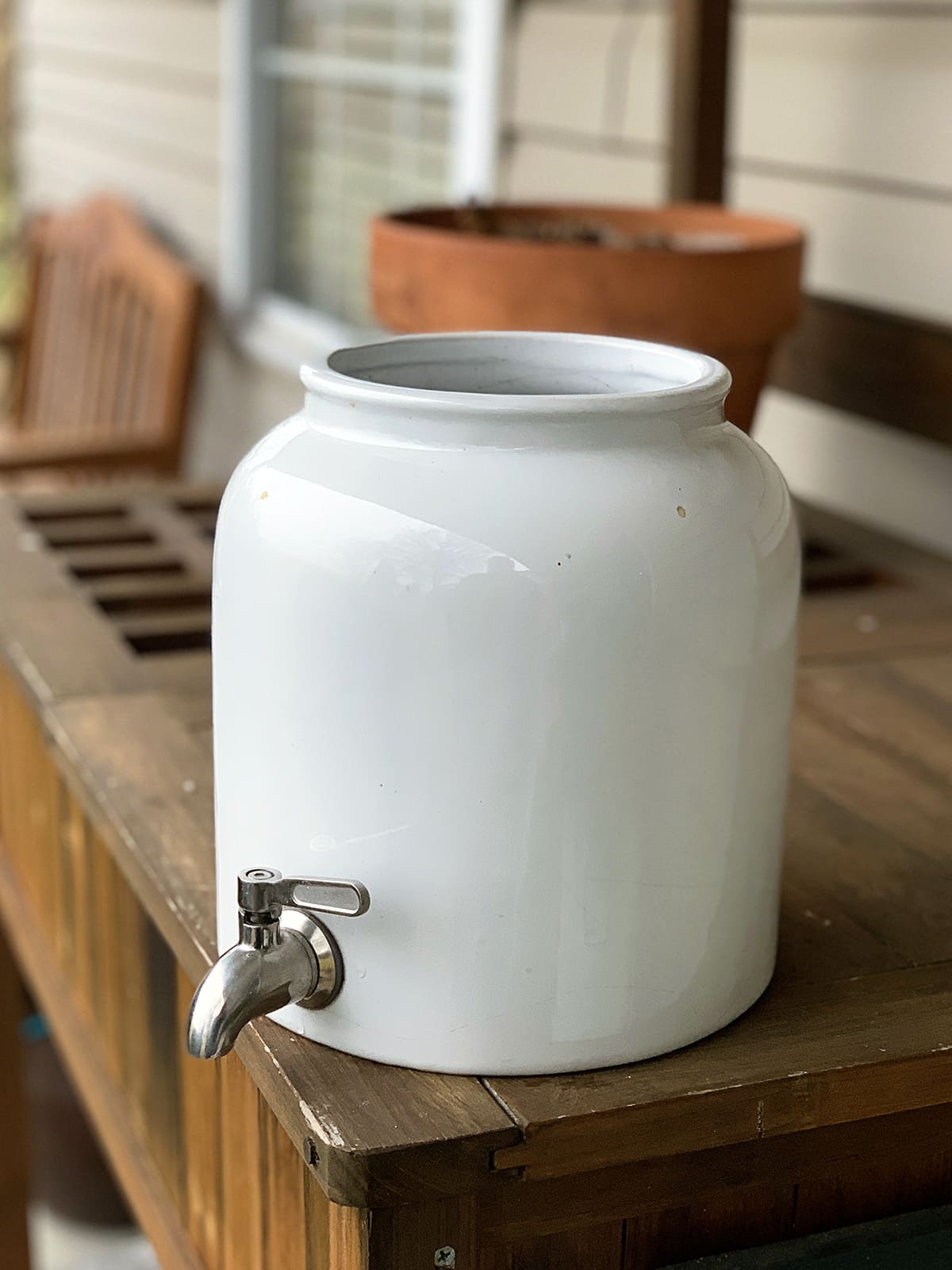 Stoneware crock beverage dispenser with a spout which will be transformed into a planter.